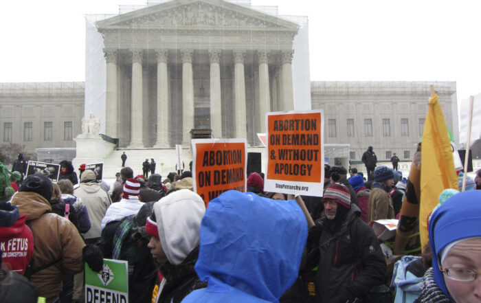 Protesters hold signs outside the U.S. Supreme Court challenging the federal abortion ban, which will have consequences on abortion training at U.S. medical schools